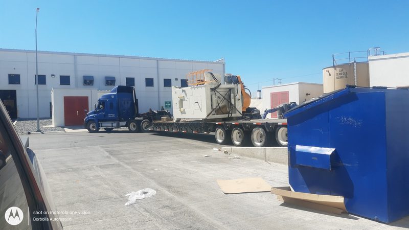 Machine moved in on a lowboy trailer.