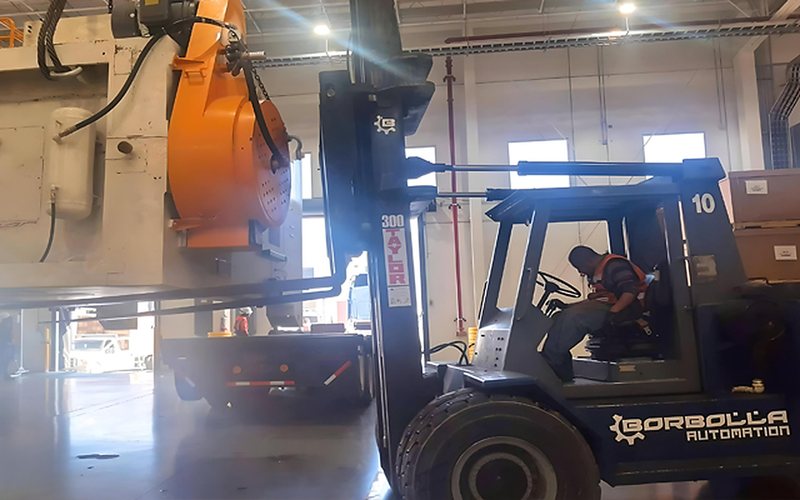 A 30-tonne forklift lifting a press into position.