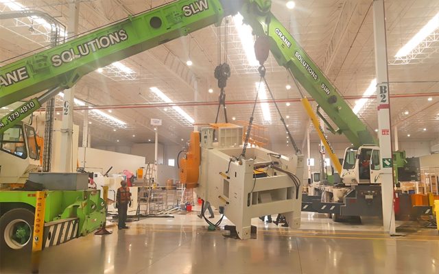 Large machine lifted into the building by mobile crane.