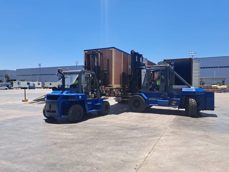 Container unloading with two forklifts working together.